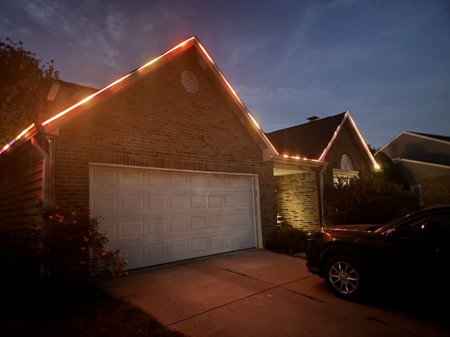 Permanent warm white roofline lighting on a Fishers, Indiana home at dusk